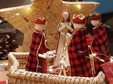 Krippe©Stadt Tauberbischofsheim_Anke Tunger Beleuchtete Weihnachtskrippe mit drei Königen in rot-schwarzem Gewand, Maria in Weiß und einem Stern aus Naturmaterialien in einem geflochtenen Korb.